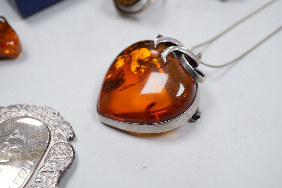 A collection of jewels, comprising: two amber pendants and an amber ring, each mounted in silver; a pair of gilt metal and enamel earrings of floral design; a pair of gilt metal earrings; a silver and cultured brooch; a